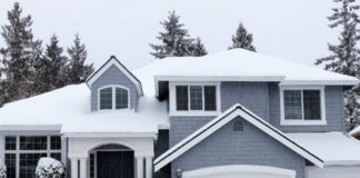 A large house with a garage surrounded by snow-covered ground