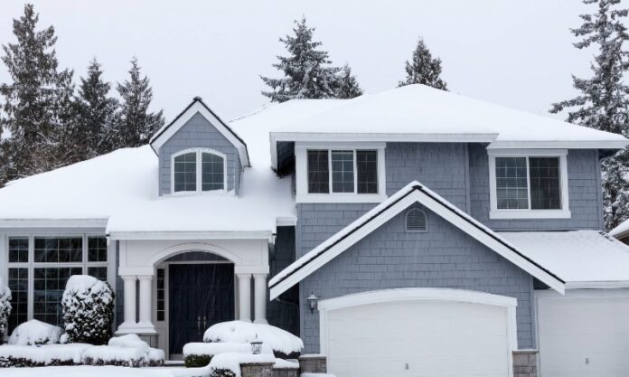 A large house with a garage surrounded by snow-covered ground