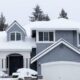 A large house with a garage surrounded by snow-covered ground